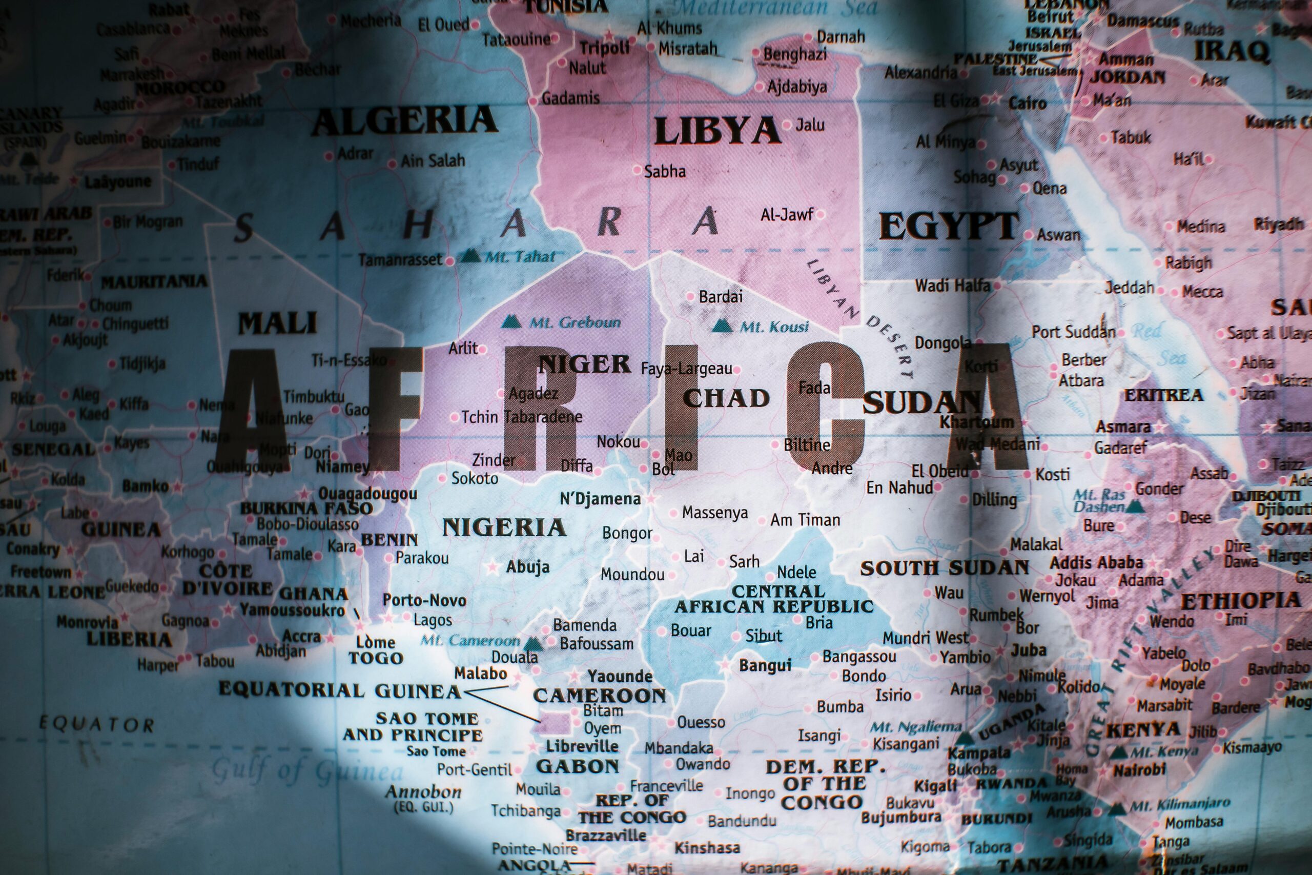 Close up of a globe centered on the continent of Africa, colors are fuschia, purple and light blue.